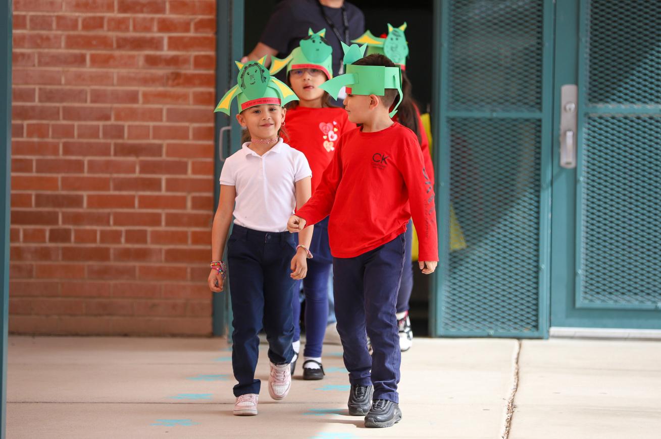 Students wearing dragon headpieces head out for the parade