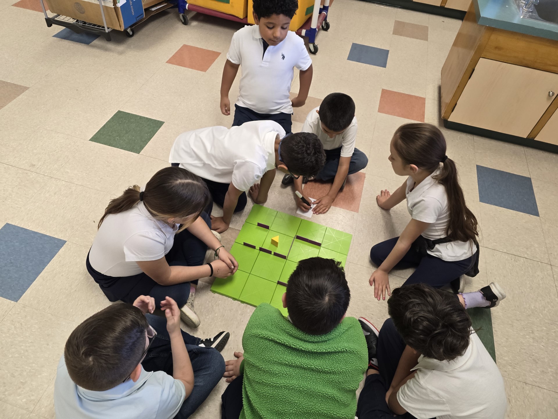 First grade students gather in a group to learn how to code with coding mice