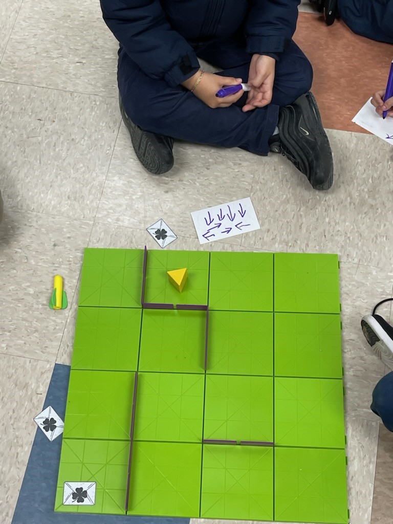 Students sit on the floor learning to code with coding mice