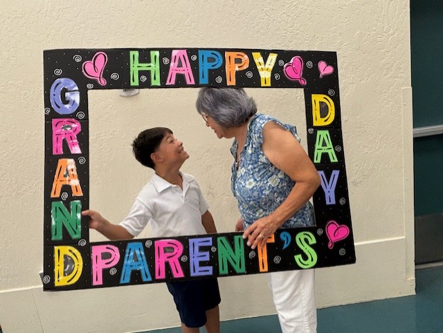 A boy and his grandma smile at each other in the Grandparents Day photo frame