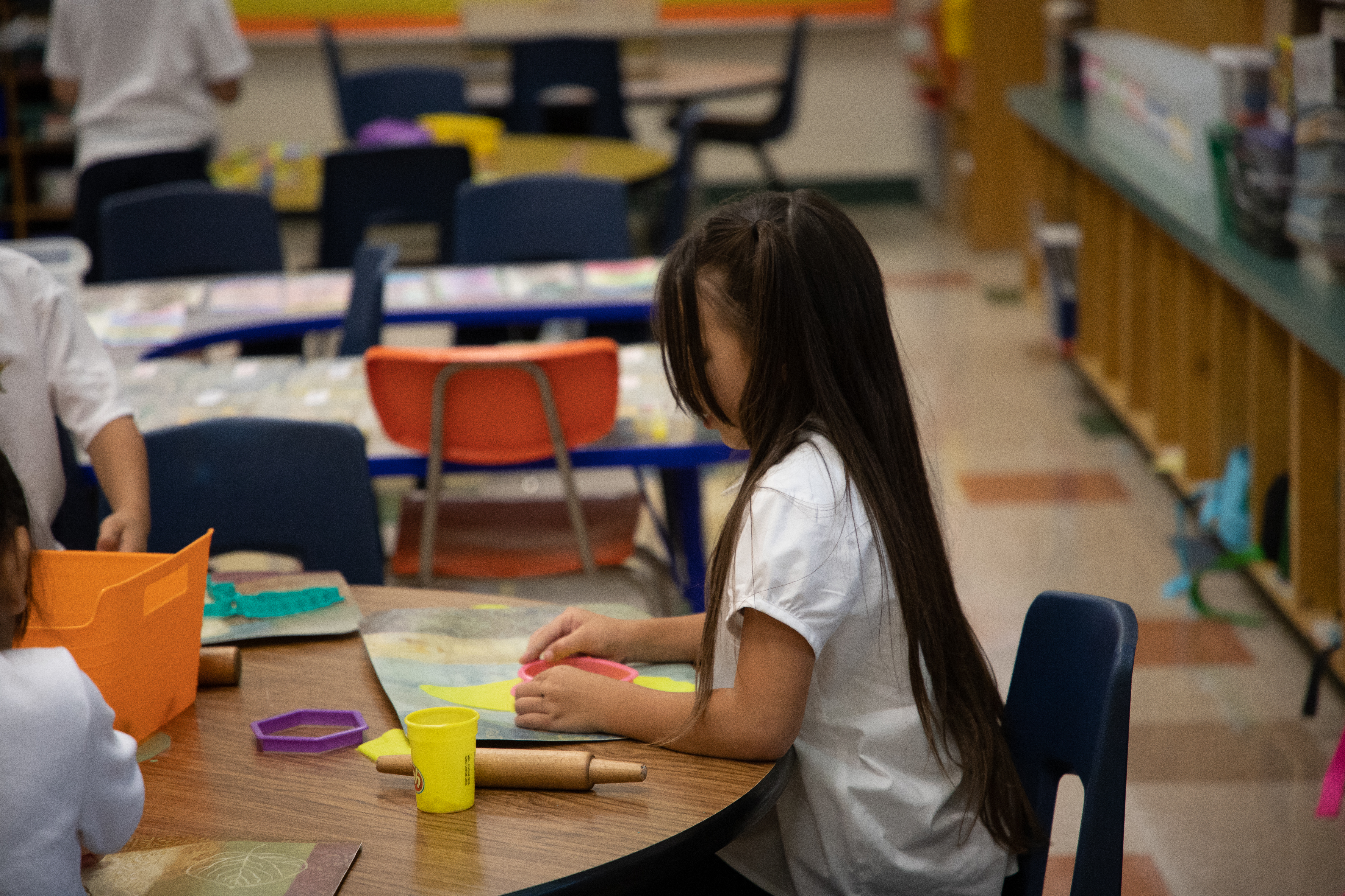 A little girl works on an art project on the first day of school