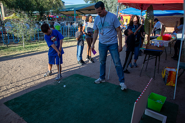 A boy plays putt-putt golf
