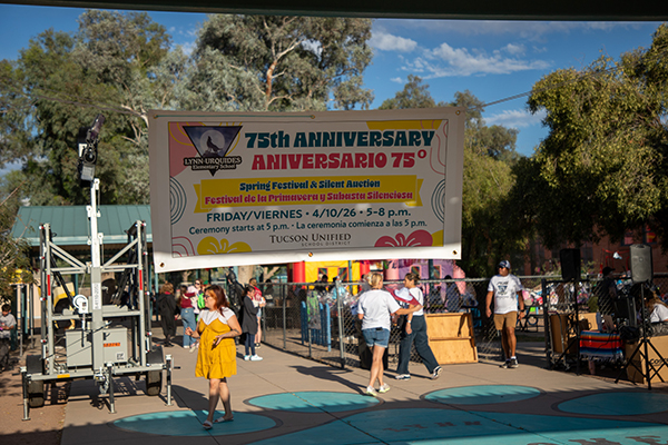 People walk under the 75th Anniversary banner