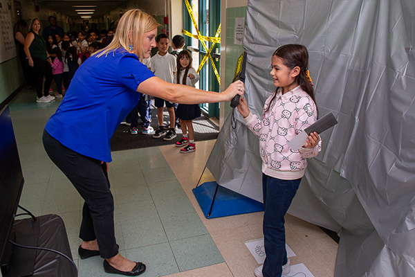 A woman pretends to wave down a girl with a security wand